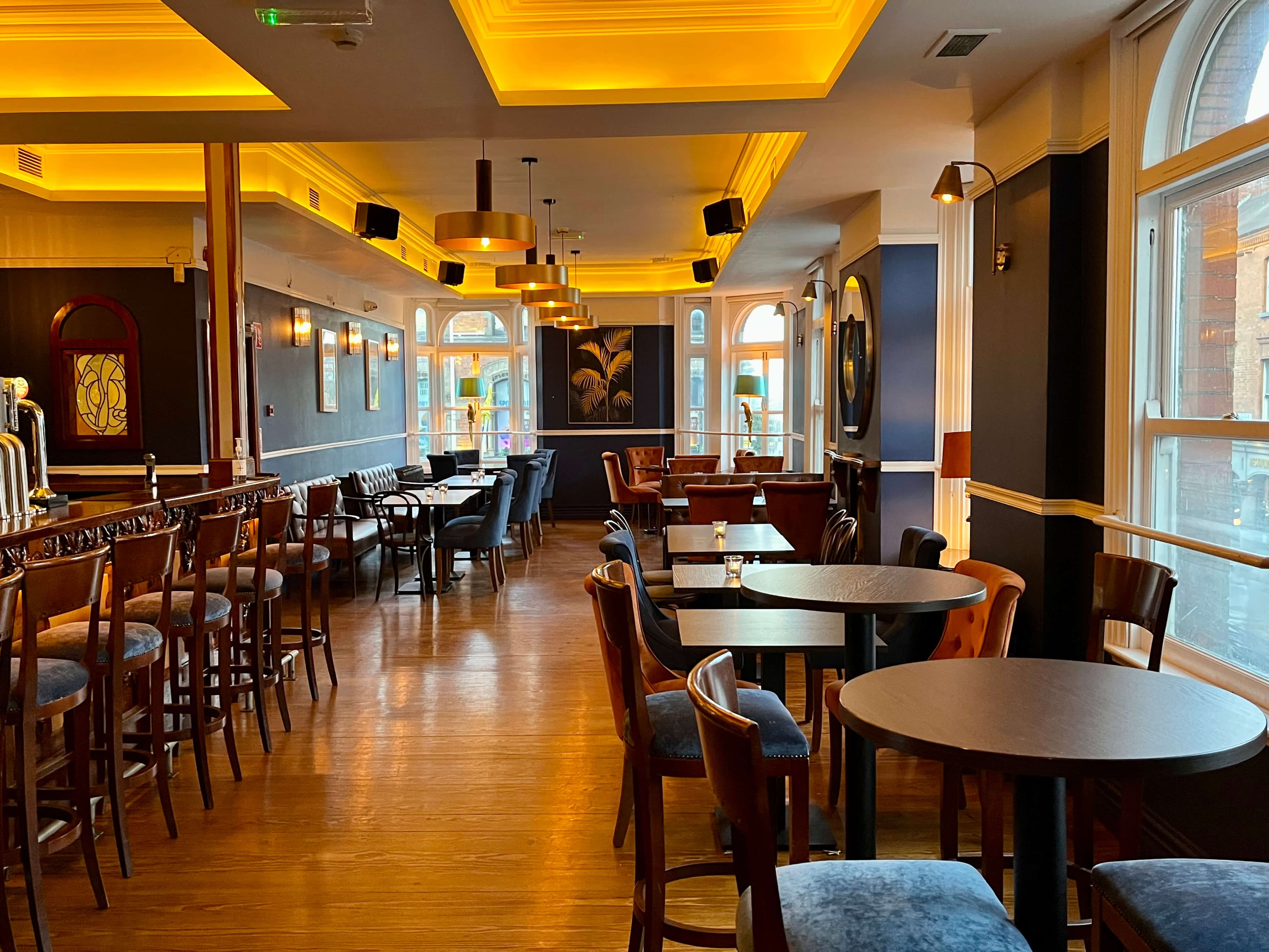 The Lounge interior — golden ceilings, arched windows, warm pendant lighting
