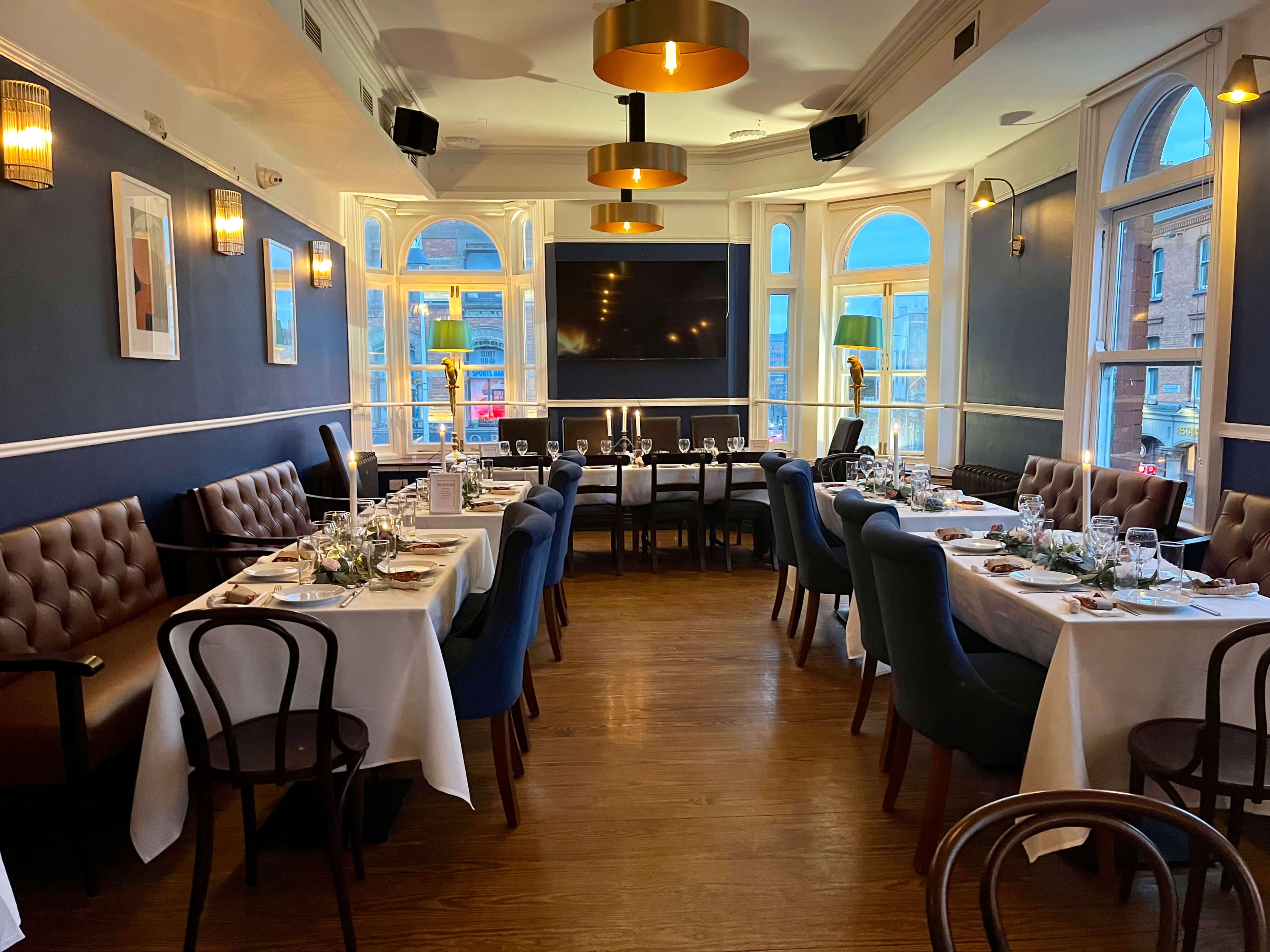 The Lounge set for a private event — white tablecloths, arched windows, candlelight