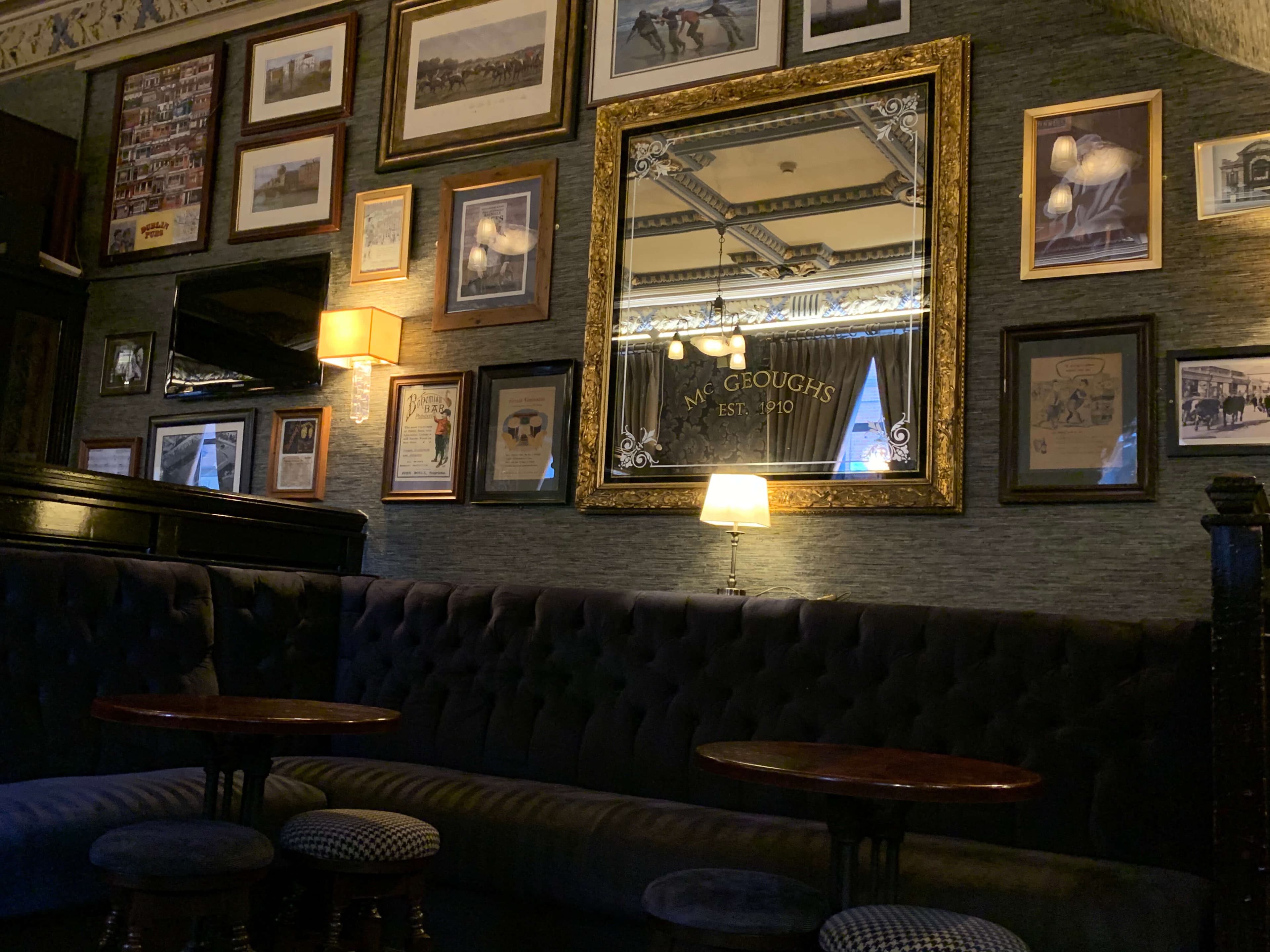 Interior of the Bohemian Pub main bar — velvet seating, framed art, Victorian mirror