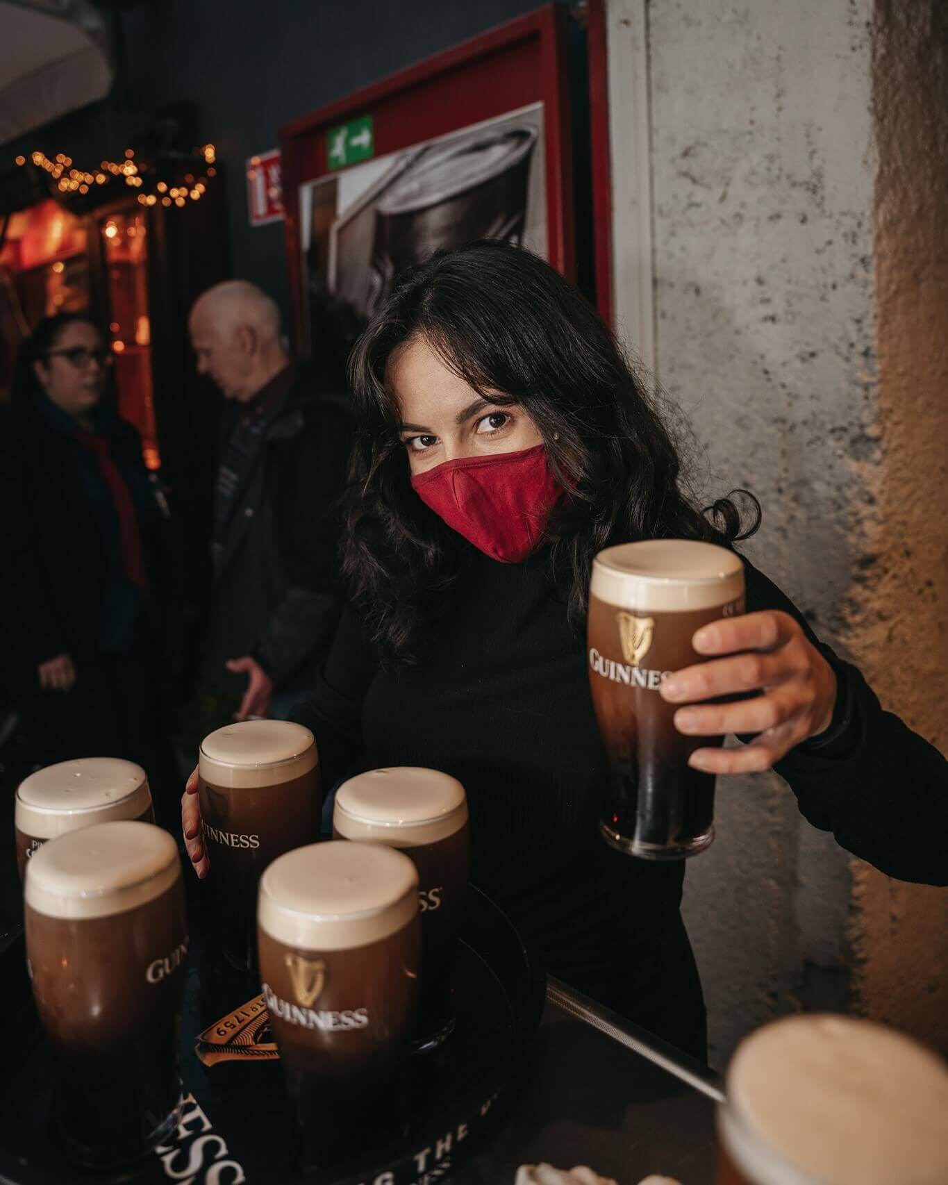 Bartender holding a freshly poured Guinness at Bohemian Pub